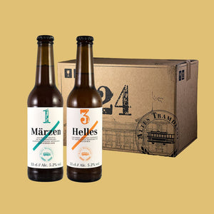 Im Vordergrund sieht man die Flaschen, links Märzen rechts Helles und im Hintergrund der 24er Karton in dem die Flaschen verpackt und versendet werden.