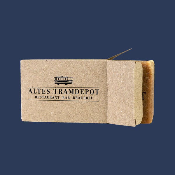 Kartonverpackung mit Tramdepot Logo drauf.