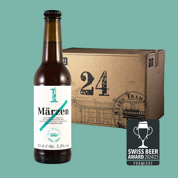 Im Vordergrund sieht man die Flasche und im Hintergrund der 24er Karton in dem die Flaschen verpackt und versendet werden.