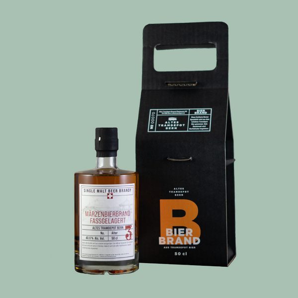 Links die Flasche und rechts die schöne schwarze Verpackung mit Tragriemen, in der die Flasche versendet wird.
