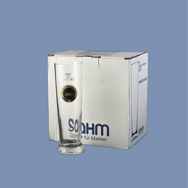 Im Vordergrund steht das Glas mit dem Tramdepot Logo drauf und im Hintergrund ist der 6er Karton, in dem die Gläser verpackt sind und geliefert werden.