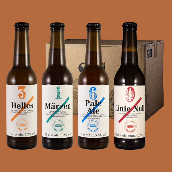 Vier Bierflaschen stehen vor dem Karton