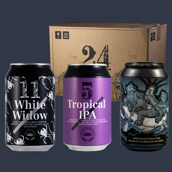 Im Vordergrund die beiden Dosen Biere. Links White Widow mit schwarzer Etikette mit weissen Spinnen und rechts das Tropical IPA mit Violetter Etikette. Im Hintergrund der 24er Karton indem die Biere geliefert werden.