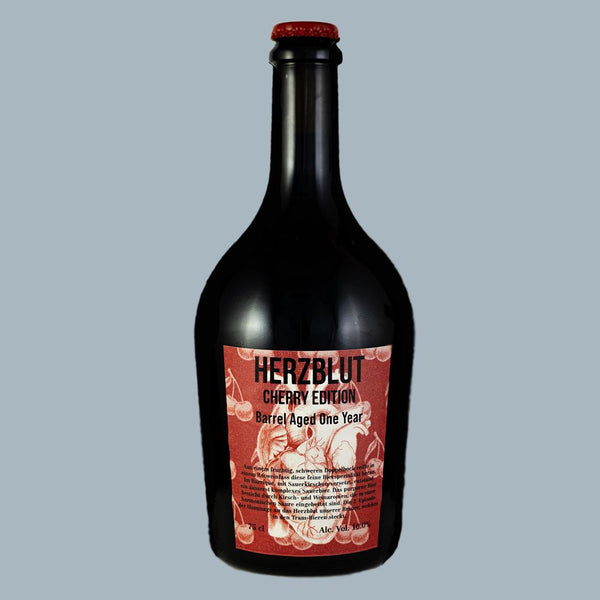 Bierflasche mit roten Kronkorken und roter Etikette mit einem weissen menschlichen Herz und Kirschen drauf.