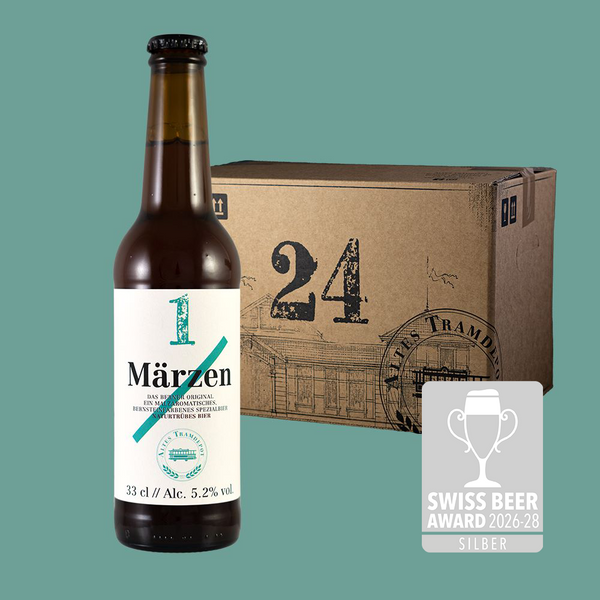 Im Vordergrund sieht man die Flasche und im Hintergrund der 24er Karton in dem die Flaschen verpackt und versendet werden.