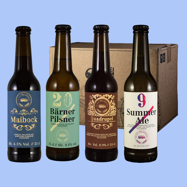 Vier verschiedene Biere vor dem Karton